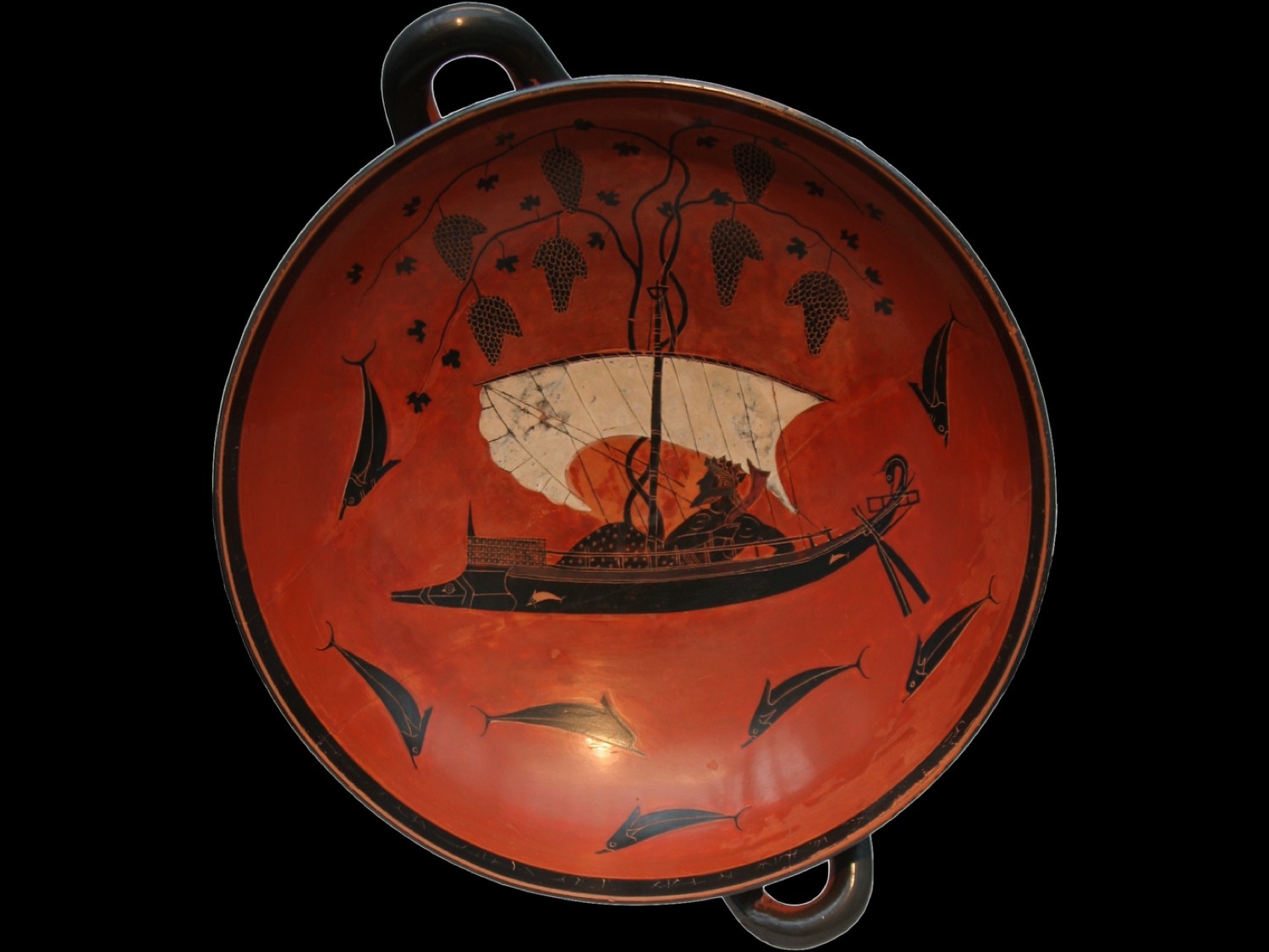 Interior of a black-figure kylix depicting Dionysus on a ship festooned with grapevines sailing among jumping dolphins